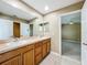 Bathroom with a double vanity, light wood cabinets, tile flooring, and access to the bedroom at 13055 Overstreet Rd, Windermere, FL 34786