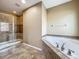 Luxurious bathroom featuring a glass-enclosed shower, soaking tub with tile surround, and modern fixtures at 13055 Overstreet Rd, Windermere, FL 34786