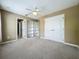Spacious bedroom with a ceiling fan, carpet, and a closet with built-in shelving at 13055 Overstreet Rd, Windermere, FL 34786