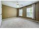 Bedroom featuring neutral walls, carpet, and two windows with blinds and decorative curtains at 13055 Overstreet Rd, Windermere, FL 34786
