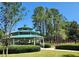 Charming gazebo with a green roof surrounded by lush landscaping and tall trees at 13055 Overstreet Rd, Windermere, FL 34786
