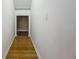 Clean hallway with light gray walls and wood floors leading to other rooms at 13055 Overstreet Rd, Windermere, FL 34786