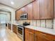 Kitchen features wood cabinets, stainless steel appliances, light countertops, and tiled backsplash at 13055 Overstreet Rd, Windermere, FL 34786