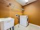 Practical laundry room with a utility sink, a washing machine, and shelving for storage at 13055 Overstreet Rd, Windermere, FL 34786