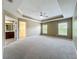 Expansive main bedroom featuring tray ceiling, carpet floors, ensuite bathroom, and a walk-in closet at 13055 Overstreet Rd, Windermere, FL 34786
