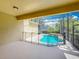 View of the caged pool area with safety fence, covered lanai and lush landscaping at 13055 Overstreet Rd, Windermere, FL 34786