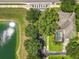 Aerial shot showcasing the backyard pool, lush landscaping, and proximity to a pond at 13055 Overstreet Rd, Windermere, FL 34786