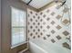 White tub with diamond tile and detachable shower head at 13055 Overstreet Rd, Windermere, FL 34786