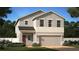 Two-story home featuring a two-car garage, neutral color palette, and manicured landscaping at 1393 Sawgrass Hammock Ln, Davenport, FL 33837