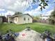 Backyard featuring lush green lawn, patio with lawn chairs and fire pit on a sunny day at 1400 Yates St, Orlando, FL 32804