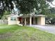 Single-story home featuring a covered carport, well-maintained lawn, and mature trees at 1400 Yates St, Orlando, FL 32804