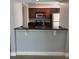 An efficient kitchen offering a breakfast bar, dark countertops, and wood cabinets at 190 Riverbend Dr # 102, Altamonte Springs, FL 32714