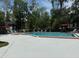 A community pool area featuring ample seating and lush, mature landscaping at 190 Riverbend Dr # 102, Altamonte Springs, FL 32714