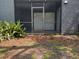 Exterior view of a screened patio with sliding glass doors and view of the yard at 190 Riverbend Dr # 102, Altamonte Springs, FL 32714