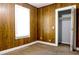 Bedroom with wooden paneling, bright window, carpet flooring, and an open closet at 211 N Randolph Ave, Kissimmee, FL 34741