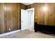 Bedroom featuring wooden paneling, an open white door, and carpet flooring at 211 N Randolph Ave, Kissimmee, FL 34741