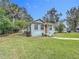 Cozy home with a well-manicured lawn, surrounded by lush greenery and mature trees at 211 N Randolph Ave, Kissimmee, FL 34741