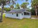 Charming home featuring a screened-in porch and beautiful mature trees creating a serene outdoor space at 211 N Randolph Ave, Kissimmee, FL 34741