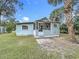 Charming home exterior featuring blue siding, screened porch, and a well-manicured lawn at 211 N Randolph Ave, Kissimmee, FL 34741
