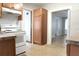 Kitchen boasts white appliances and wood cabinets with a view of connecting rooms at 211 N Randolph Ave, Kissimmee, FL 34741