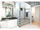 Stylish bathroom with a glass shower, vanity, and decorative wallpaper at 235 Promenade Cir, Lake Mary, FL 32746