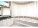 Elegant bathroom showcasing a soaking tub, vanity area and a large window with natural light at 235 Promenade Cir, Lake Mary, FL 32746