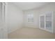 Bright bedroom features neutral carpet, white walls and shutters, and sliding door access at 235 Promenade Cir, Lake Mary, FL 32746