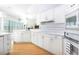 Bright kitchen with white cabinets, tile counters and backsplash, and hardwood floors at 235 Promenade Cir, Lake Mary, FL 32746