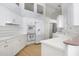 Well-lit kitchen with white cabinets, tile counters and backsplash, and modern appliances at 235 Promenade Cir, Lake Mary, FL 32746