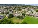 A serene aerial view showcases a residential community with manicured lawns nestled next to a wide expanse of green space at 2681 Cabernet Cir, Ocoee, FL 34761