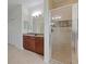 Bright bathroom boasts a glass shower, wood cabinets, granite countertop, and double door closet at 2681 Cabernet Cir, Ocoee, FL 34761