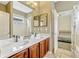 Bathroom with double sinks, wood cabinets, and a door leading into a bedroom at 2681 Cabernet Cir, Ocoee, FL 34761