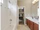 Bathroom with double sinks, wood cabinets, and a doorway to another room at 2681 Cabernet Cir, Ocoee, FL 34761