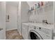 Functional laundry room with washer, dryer, storage shelves, and easy access at 2681 Cabernet Cir, Ocoee, FL 34761
