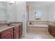 Main bathroom with double vanity, large bathtub, and walk-in shower at 2681 Cabernet Cir, Ocoee, FL 34761
