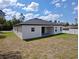 The backyard features a covered patio with a sliding glass door, set on a spacious lot with grass at 2699 Sw 161St Loop, Ocala, FL 34473