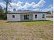 Backyard view of the home's rear exterior with a covered patio, grassy yard, and privacy fence at 2699 Sw 161St Loop, Ocala, FL 34473