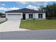 Single-story home featuring white siding, black trim, a dark roof, and a two-car garage at 2699 Sw 161St Loop, Ocala, FL 34473