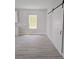 Open-concept living area with a barn door and views to the green backyard through a window at 2699 Sw 161St Loop, Ocala, FL 34473