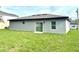 Spacious backyard with lush green grass and a sliding glass door leading inside at 319 Anchovie Ct, Poinciana, FL 34759