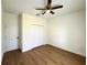 Bedroom features a ceiling fan, closet, and wood-look flooring at 319 Anchovie Ct, Poinciana, FL 34759