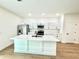 Modern kitchen featuring a large island with quartz countertops, white cabinets and stainless steel appliances at 319 Anchovie Ct, Poinciana, FL 34759