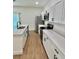 Modern kitchen with stainless steel appliances, white cabinets, and hardwood floors at 319 Anchovie Ct, Poinciana, FL 34759