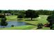 Scenic aerial view of lush golf course with a small lake and a charming bridge in the landscape at 3207 Westridge Blvd # 104, Orlando, FL 32822