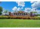 Community sign for Ventura Country Club, framed by colorful landscaping and lush green lawns at 3207 Westridge Blvd # 104, Orlando, FL 32822