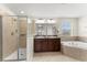 This bathroom boasts a glass-enclosed shower, soaking tub, and double vanity with granite counters at 3426 Schoolhouse Rd, Harmony, FL 34773