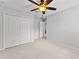 A bright bedroom featuring plush carpeting, a ceiling fan, and a spacious closet for optimal storage at 3426 Schoolhouse Rd, Harmony, FL 34773
