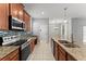 Modern kitchen featuring stainless steel appliances, granite countertops, and ample cabinet space at 3426 Schoolhouse Rd, Harmony, FL 34773