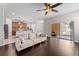 An open living room with hardwood floors, a ceiling fan and direct access to the backyard at 3426 Schoolhouse Rd, Harmony, FL 34773