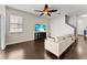 Well lit living room with hardwood floors and a large TV with a ceiling fan at 3426 Schoolhouse Rd, Harmony, FL 34773